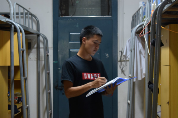 助理指导陈轩正在对寝室内务情况进行登记 助理指导陈轩正在对寝室内务情况进行登记