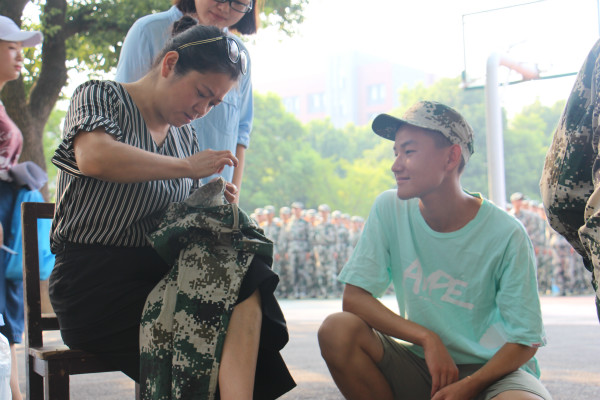 分院学工秘书周红波老师为学生修补军训服 分院学工秘书周红波老师为学生修补军训服